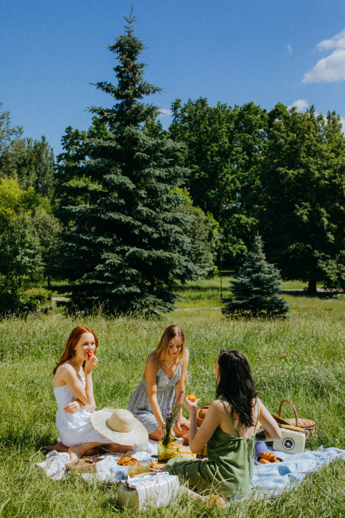 Three friends having a picnic in a garden.