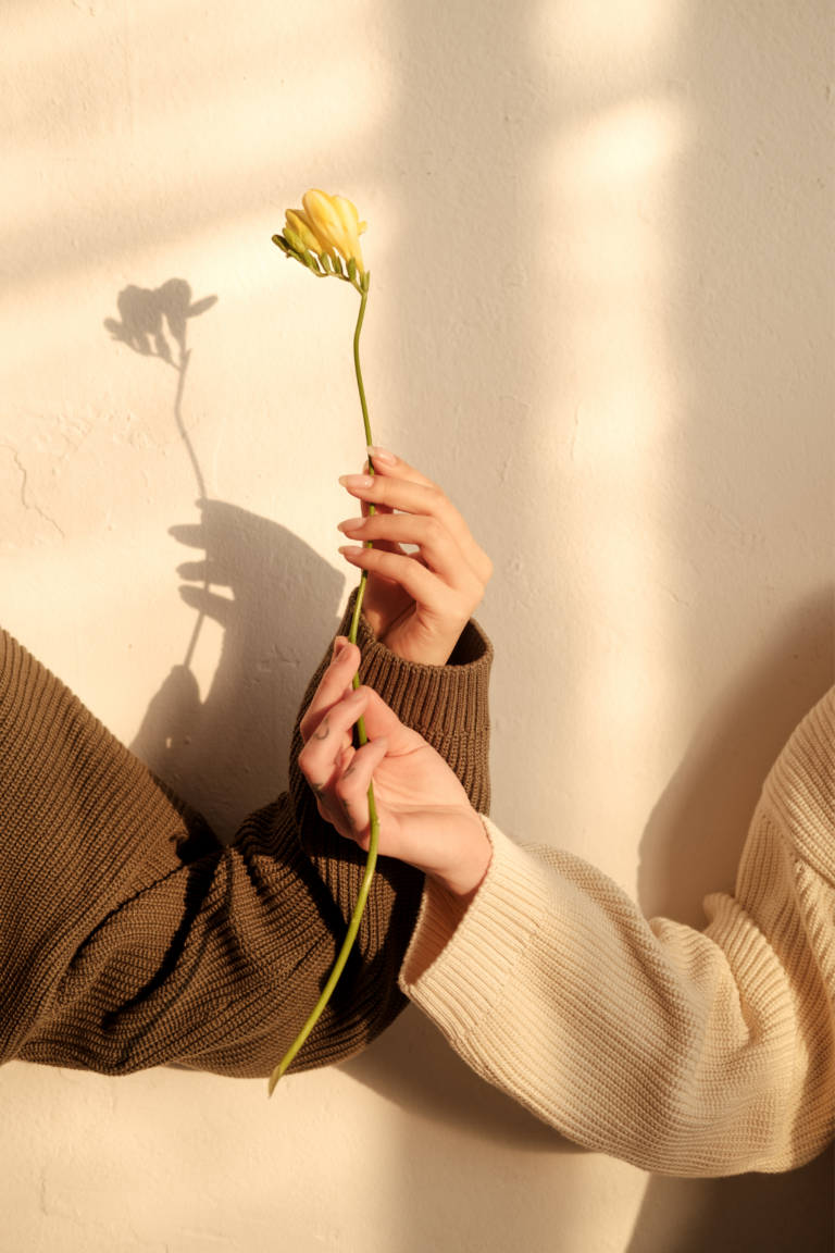 Two women holding a flower