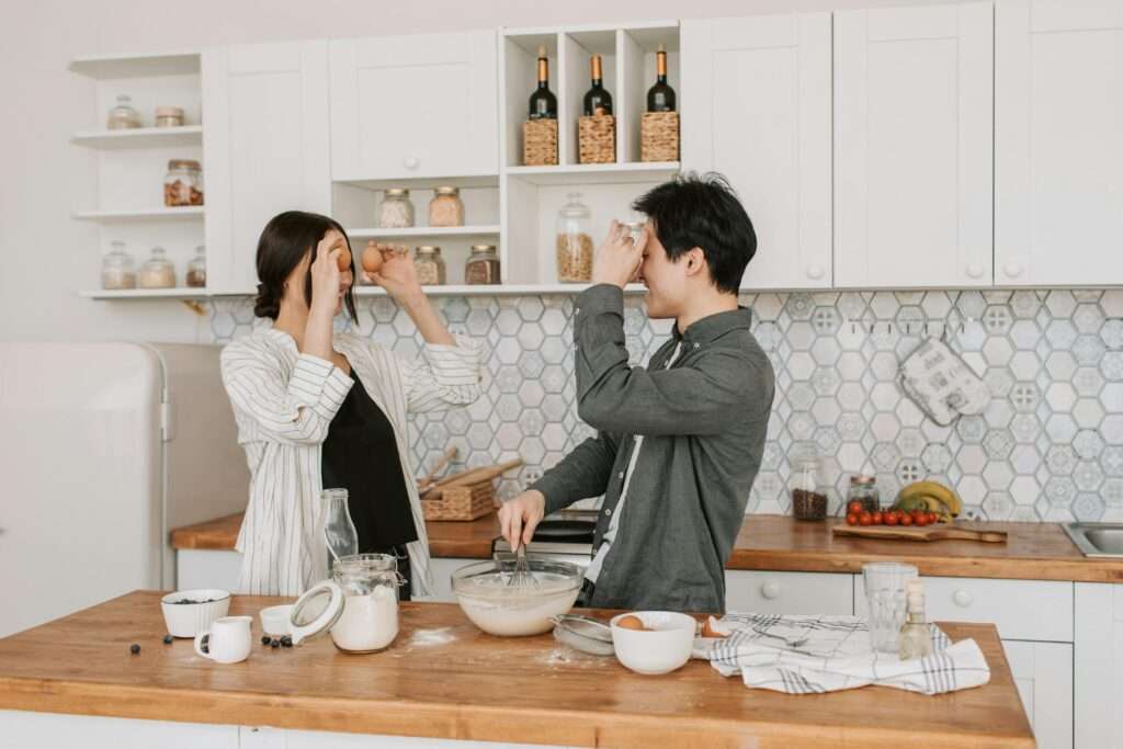 How to reset your relationship by trying new hobbies with your significant other. Image of a couple baking in a kitchen.