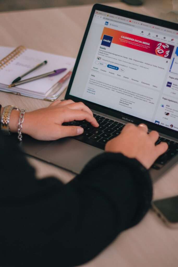 How to reinvent yourself professionally by building your personal brand on LinkedIn. Image of woman typing on LinkedIn.
