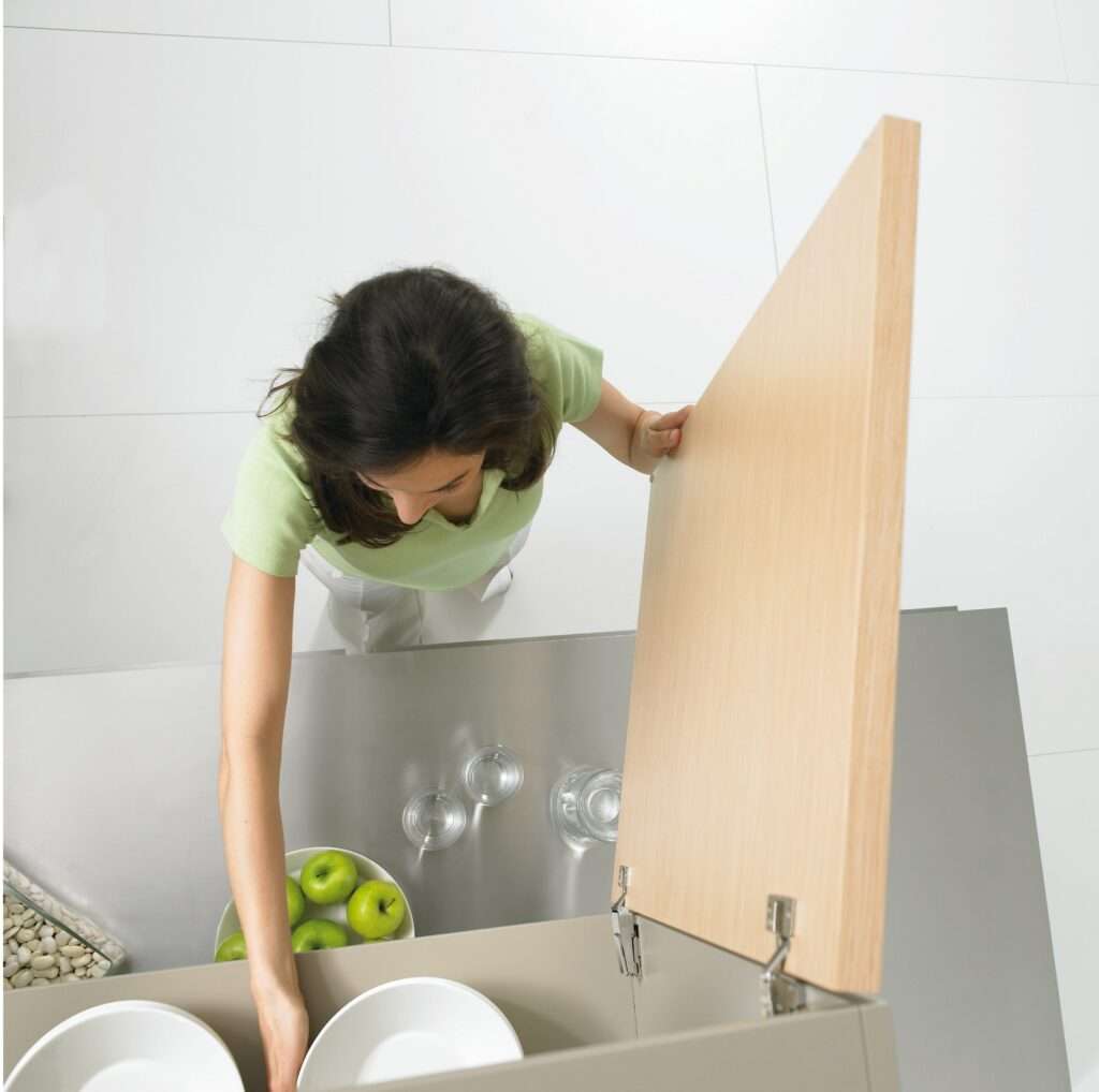 Woman putting away dishes.
