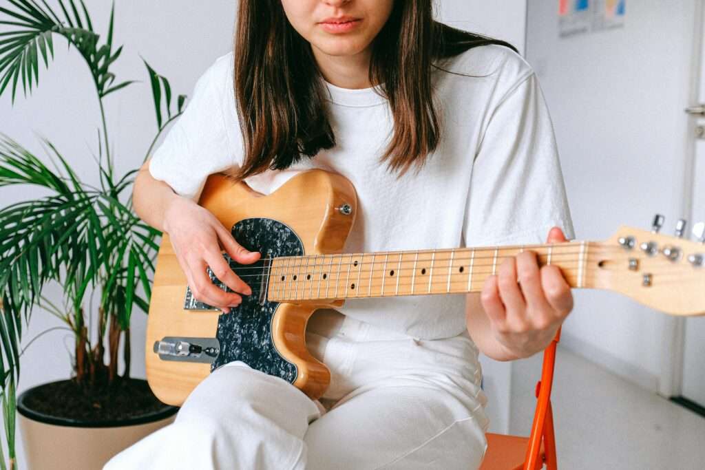 Woman playing a guitar.