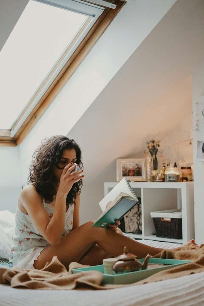 Woman drinking tea and reading a book.