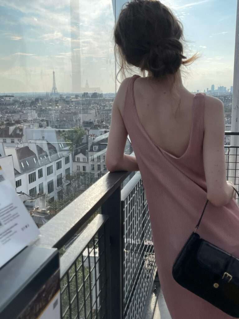 A woman on a balcony overlooking Paris 