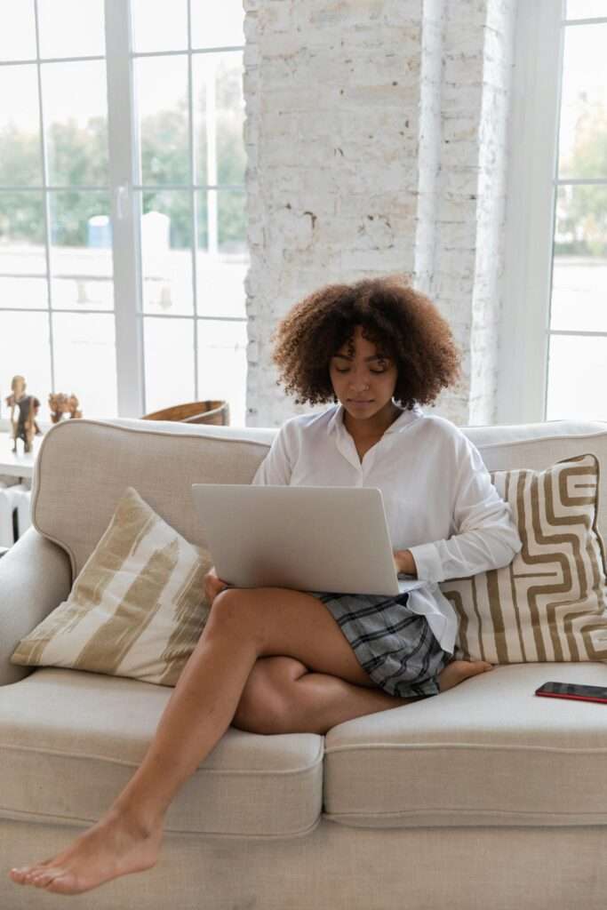 A woman on her laptop while sitting on the couch