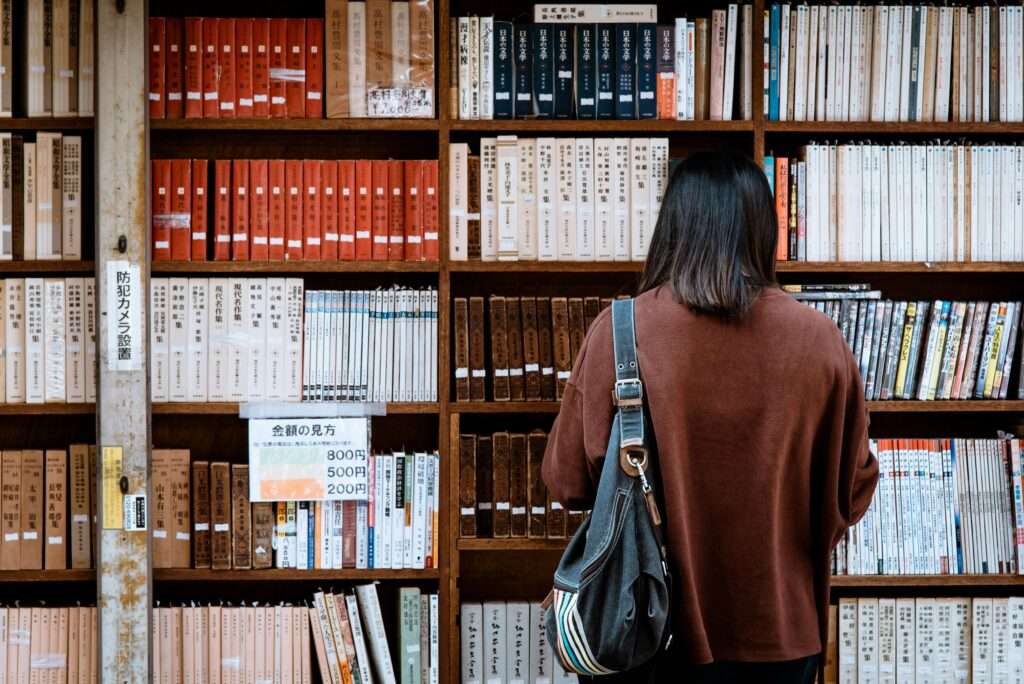 A woman in a library looking at books