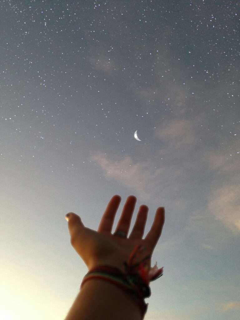 Image of a woman taking a picture while her hand is to the sky