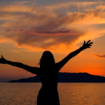 Woman on the beach in the sunset.