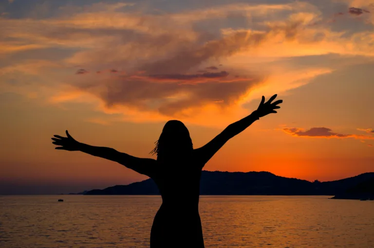 Woman on the beach in the sunset.