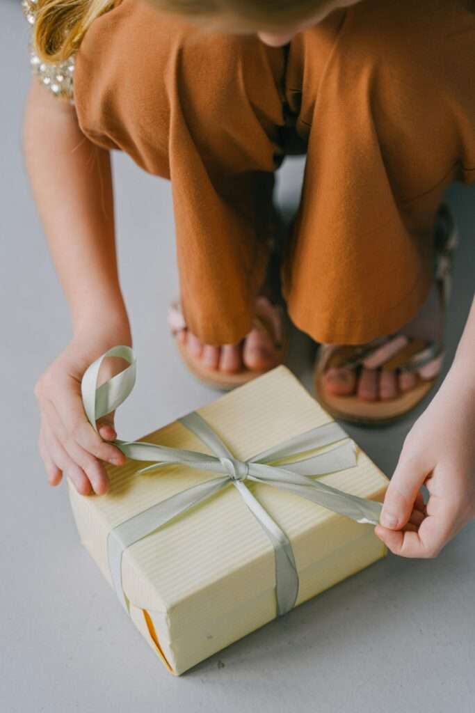 A close up image of a woman tying a gift