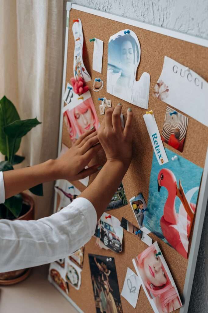 An image of a woman's hand putting together a vision board.