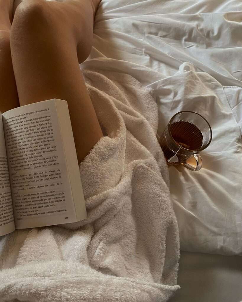 Image of a girl reading a book and drinking tea.