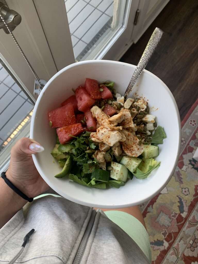 Image of a watermelon, chicken breast, cucumber, and nuts salad.