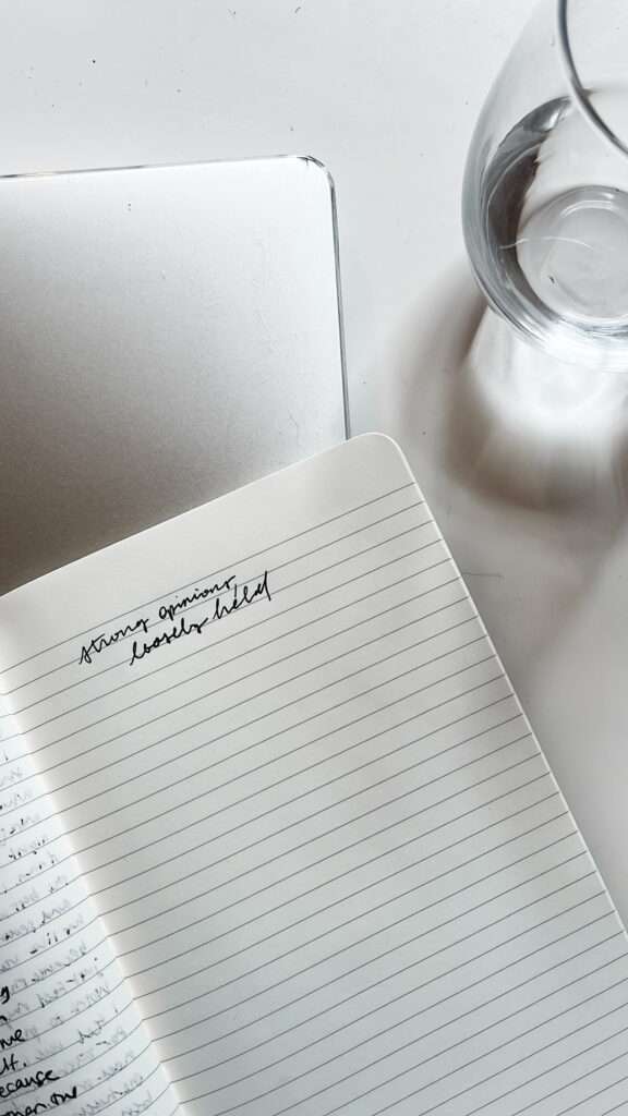 Image of a notebook and a glass of water on a white background.