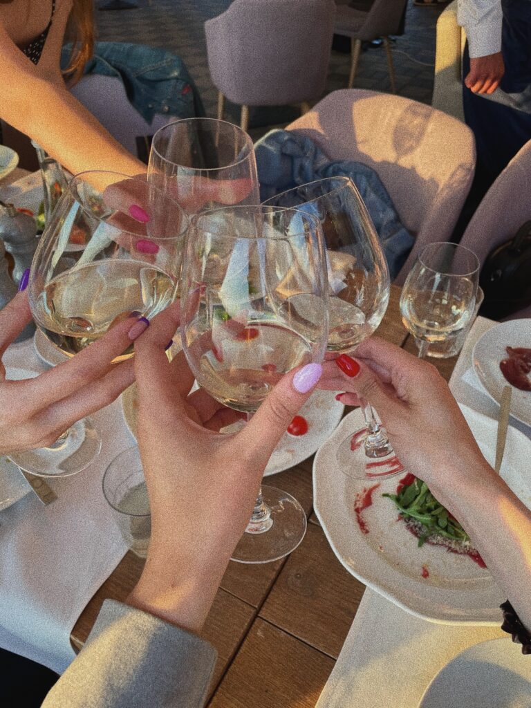 Image of a group of women hands, toasting their glasses.