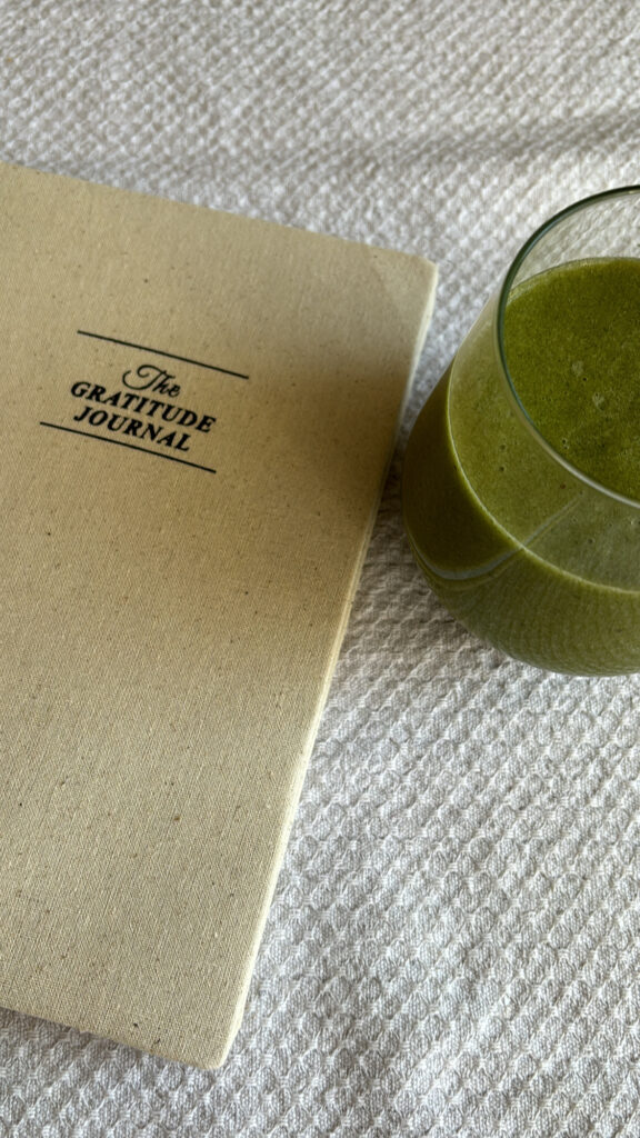 Image of a journal and a glass of green juice.